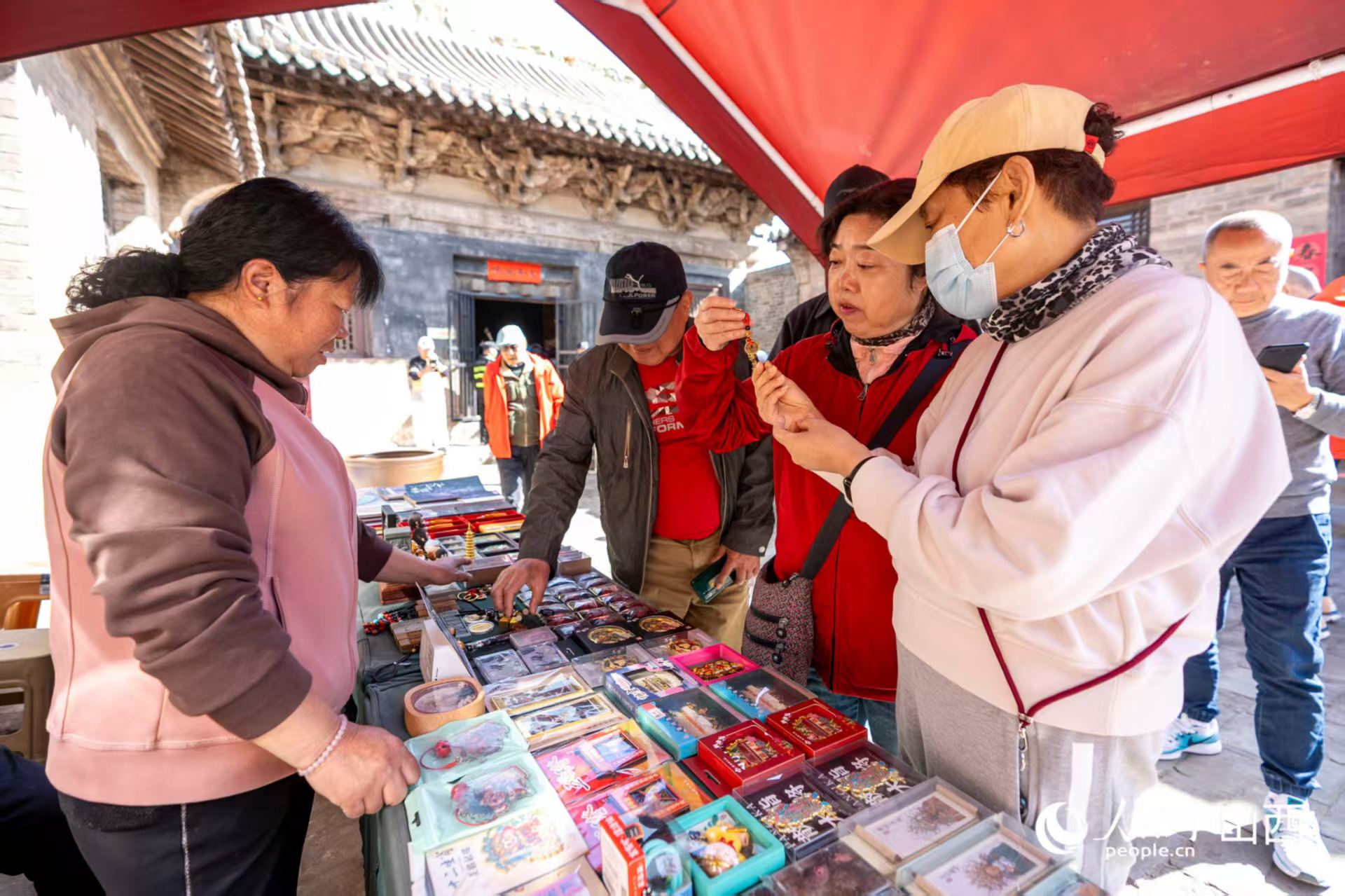 游客在山西省高平市鐵佛寺選購(gòu)文創(chuàng)產(chǎn)品。人民網(wǎng)記者 盧鵬宇攝