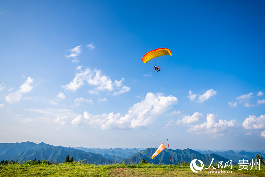 游客在野玉海飛行營地乘動力滑翔傘體驗(yàn)云端觀景。人民網(wǎng)記者 涂敏攝