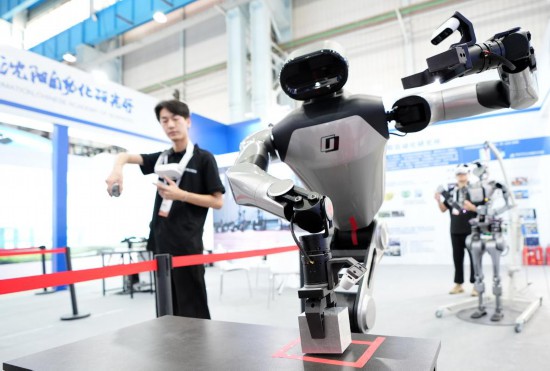 9月5日，在沈陽(yáng)的2025全球工業(yè)互聯(lián)網(wǎng)大會(huì)的展覽區(qū)現(xiàn)場(chǎng)，中國(guó)科學(xué)院沈陽(yáng)自動(dòng)化研究所的機(jī)器人工程師在調(diào)試具身智能操作系統(tǒng)。新華社記者 李鋼 攝