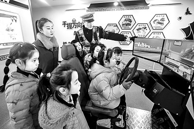 山東省榮成市公安局道路交通安全宣傳教育基地，交警帶領(lǐng)小學(xué)生現(xiàn)場體驗?zāi)M駕駛。新華社發(fā)