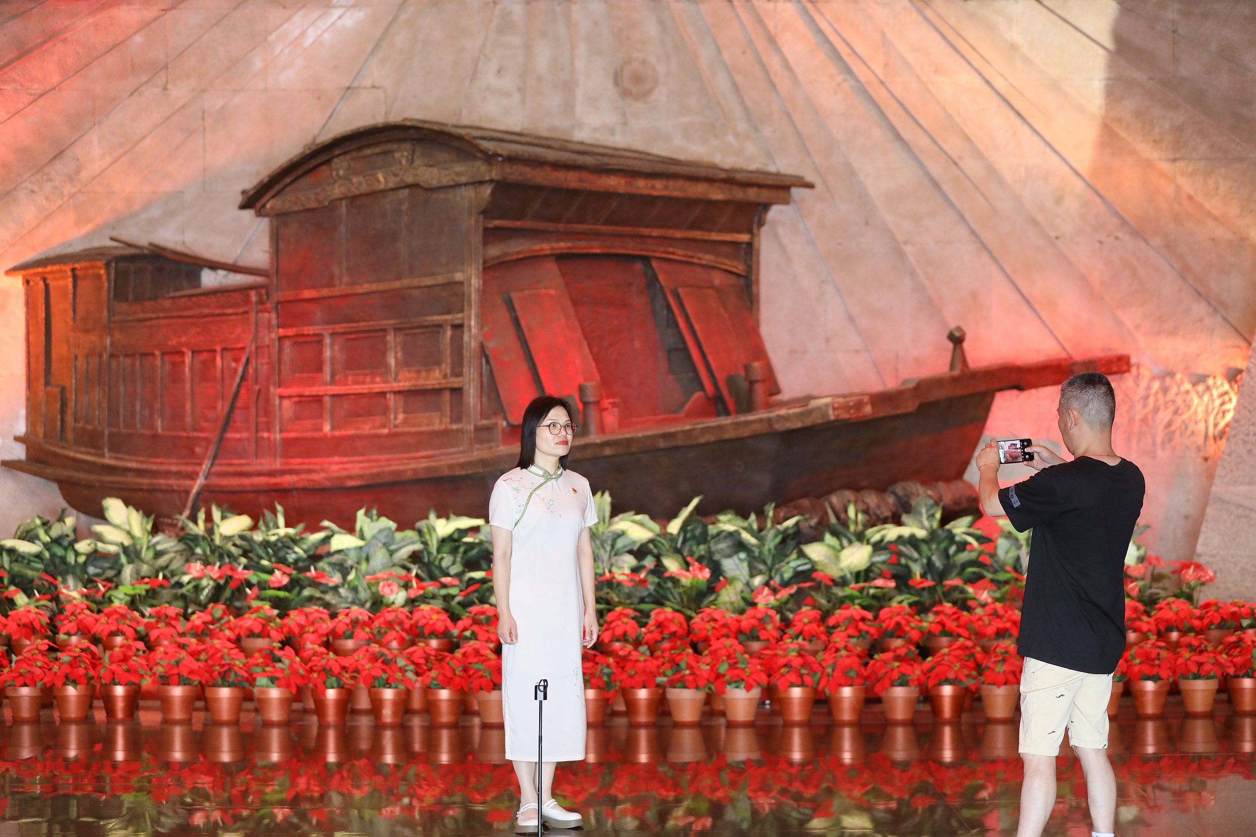 2025年6月24日，浙江嘉興，游客在南湖革命紀念館與紅船雕塑合影。（圖片來源：視覺中國）