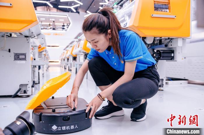 圖為員工在調(diào)試AGV搬運機器人?！±钅宪?攝